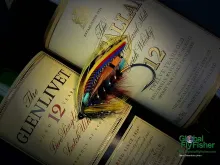 Computer screen wallpaper: Salmon fly over scotch bottles.